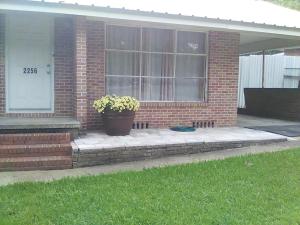 a house with a porch with a potted plant on it at Mid-Century Modern meets Cajun Creole in Baton Rouge