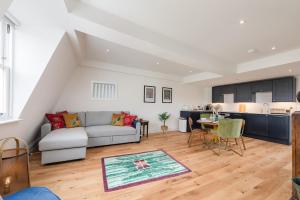 uma sala de estar com um sofá e uma cozinha em Bath Abbey View - City Centre em Bath