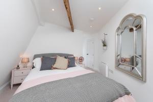 ein Schlafzimmer mit einem großen Bett und einem Spiegel in der Unterkunft Bath Abbey View - City Centre in Bath
