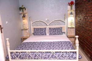 een slaapkamer met een wit bed en een bakstenen muur bij Little Birds Paradise in Ruhengeri