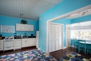 a kitchen with blue walls and a kitchen with a table at 6 Bedroom 6 Bath Guesthouse on Duval Street in Key West