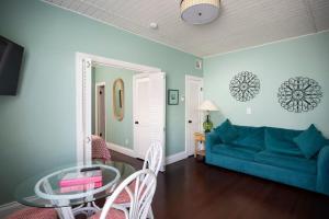 un salon avec un canapé bleu et une table en verre dans l'établissement 6 Bedroom 6 Bath Guesthouse on Duval Street, à Key West