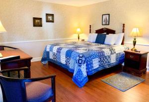 1 dormitorio con 1 cama con manta azul y blanca en Cedar Crest Inn, en Camden