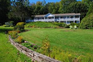 een groot huis op een heuvel met een tuin bij Cedar Crest Inn in Camden