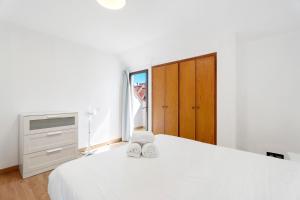 biała sypialnia z białym łóżkiem i oknem w obiekcie Family Duplex Altamira Playa Las Americas Tenerife South w Aronie +24 zdjęcia
