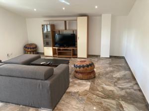 sala de estar con sofá y TV de pantalla plana en Attico Marsiglie en Casal Fiumanese