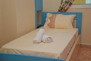 uma cama com duas toalhas em cima em Apartament 47 em Gjirokastër