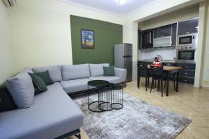 uma sala de estar com um sofá e uma cozinha em Apartament 47 em Gjirokastër