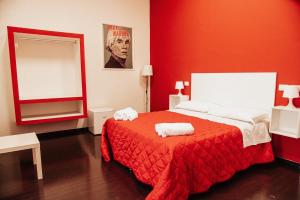 a red bedroom with a bed and a mirror at B&B Art in Reggio Calabria