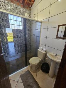 uma casa de banho com um WC, um chuveiro e um lavatório. em Chalés Pão Sobre as Águas em Carrancas