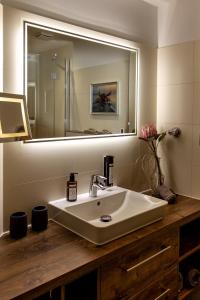 ein Badezimmer mit einem Waschbecken und einem großen Spiegel in der Unterkunft Ferienwohnung Krabbe in Wangerooge