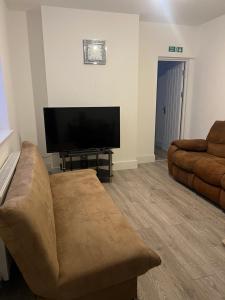 salon z kanapą i telewizorem z płaskim ekranem w obiekcie Ashfield New Place w mieście Newcastle under Lyme