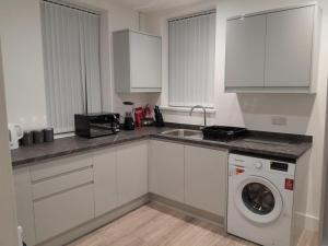 a kitchen with a sink and a washing machine at Ashfield New Place in Newcastle under Lyme