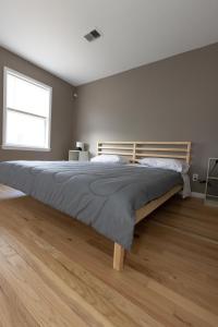 1 dormitorio con 1 cama grande y cabecero de madera en Mins from NYC Bright & Spacious 4-Bed Unit, en Jersey City
