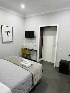 um quarto com uma cama, uma secretária e uma televisão em AD Vatican Luxury Rooms em Roma