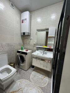 a bathroom with a toilet sink and a washing machine at Dushanbe Center in Dushanbe