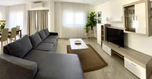 sala de estar con sofá y TV en Condominio 2 habitaciones frente al mar, en Roatan
