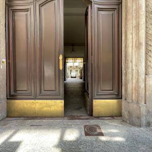 une porte ouverte menant à un couloir dans un bâtiment dans l'établissement NONPERTUTTI PIAZZA CASTELLO Senior e famiglie TOP, à Turin