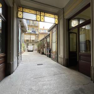une rue vide avec un bâtiment doté d'un vitrail dans l'établissement NONPERTUTTI PIAZZA CASTELLO Senior e famiglie TOP, à Turin