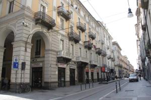 un bâtiment situé sur le côté d'une rue de la ville dans l'établissement NONPERTUTTI PIAZZA CASTELLO Senior e famiglie TOP, à Turin