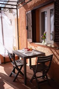 une table et deux chaises assises sur une terrasse dans l'établissement MONOLOCALE STUDIO Zia Make, à Marinella