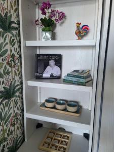un estante de libros con tazones y una foto de un hombre en Duval Street Suite w parking and heated pool, en Key West