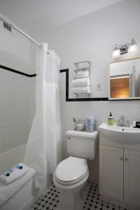 Baño blanco con aseo y lavamanos en Duval Street Suite w parking and heated pool, en Key West