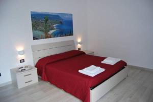 a bedroom with a red bed with two towels on it at Le Mulinare - Bed & Breakfast in Drapia +21 photos