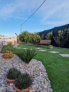 Un parque con un banco y algunas plantas y césped. en Beautiful Holiday Home "Villa Luka", en Kaštel Štafilić