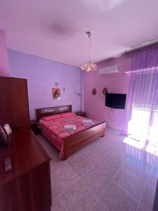 ein Schlafzimmer mit einem Bett und einem TV in der Unterkunft Casa vacanza Alcamo Marina in Alcamo