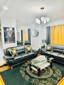 uma sala de estar com sofás de couro preto e uma mesa em Newly renovated first floor apartment getaway em Springfield