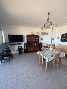 ein Wohnzimmer mit einem Tisch und einem TV in der Unterkunft Casa vacanza Alcamo Marina in Alcamo