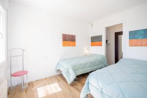 1 dormitorio blanco con 1 cama y 1 silla en Casa Mediterrani & piscina comunitaria junto Barcelona, en Alella