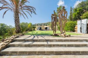 a set of stairs with a statue and palm trees at Casa Mediterrani & piscina comunitaria junto Barcelona in Alella
