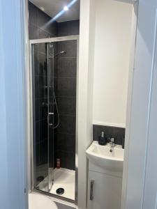 y baño con ducha, aseo y lavamanos. en Ashfield New Place, en Newcastle-under-Lyme