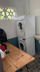 a washing machine sitting next to a wooden table at MBS Studio LA CARAPA in Guenouillet