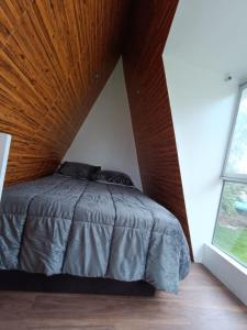 a bedroom with a bed with a wooden ceiling at Vallecito Lodge in Muyurina
