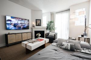 a living room with a bed and a table and a tv at Ruby 2 BR apt in MiracleMile in Los Angeles