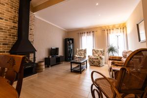 a living room with a fireplace and a couch and chairs at La Venta Casa Rural in Benitachell
