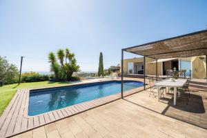 una piscina con una mesa y una casa en Casa Mediterrani & piscina comunitaria junto Barcelona, en Alella