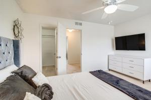a white bedroom with a bed and a flat screen tv at Inviting Denver Home with Yard about 6 Mi to Airport! in Aurora