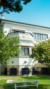 un edificio blanco con un banco delante en Espinho Vintage - Alojamento de Charme en Espinho