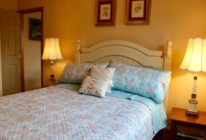 Tumalo的住宿－Rocking CR Ranch Guesthouse，一间卧室配有一张带两盏灯和两个枕头的床。