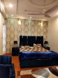 a bedroom with a bed and two lamps and a couch at Tranquil apartments in Islamabad
