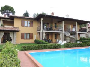 a house with a swimming pool in front of it at Apartments I Ciclamini in Moniga
