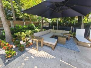 a patio with a couch and a table and an umbrella at Two Duval Street Suites w pool in Key West