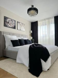 - une chambre avec un grand lit et des oreillers noirs et blancs dans l'établissement Elena Gestion, à Marseille