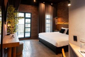 a bedroom with a bed and a brick wall at The Art Hotel Medellin in Medellín