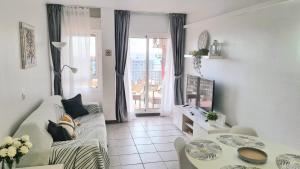 een woonkamer met een bank en een tafel bij Benalmadena Minerva - Ocean view 1 Bedroom apartment in Benalmádena