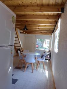 een keuken met een tafel en stoelen en een koelkast bij Duplex en Santa Clara para 4/5 personas in Santa Clara del Mar